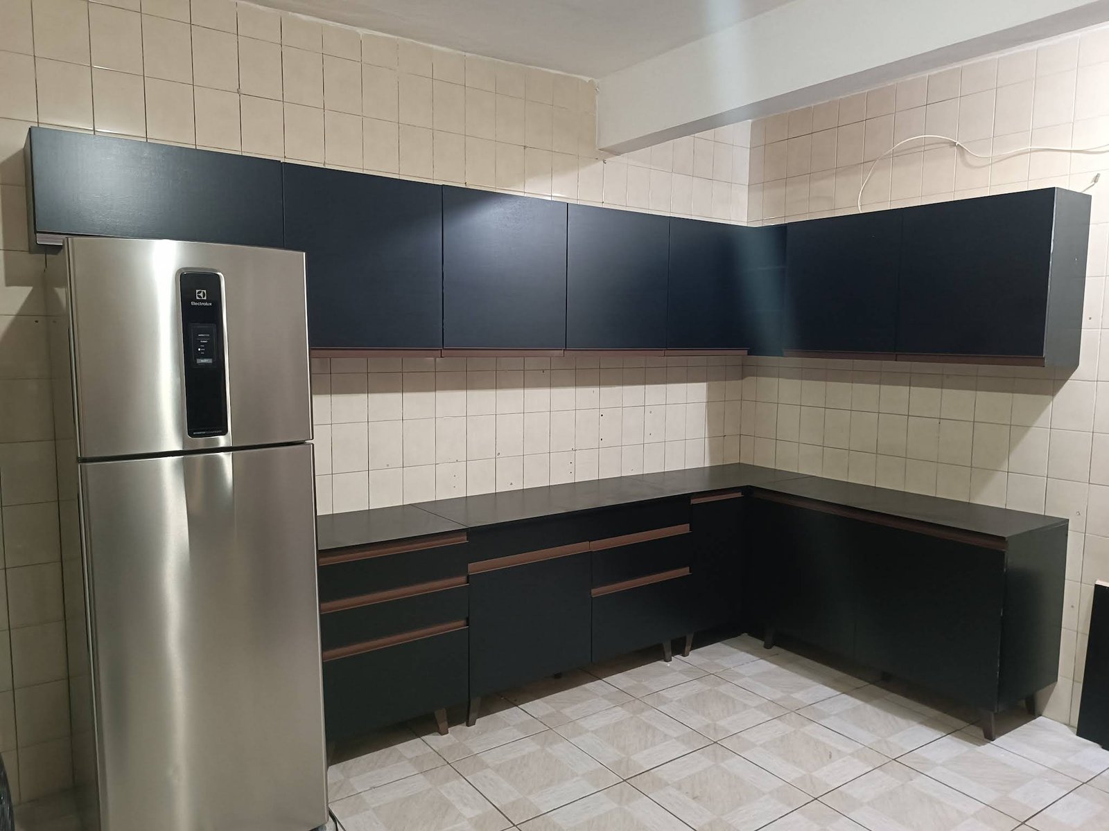 Armários de cozinha escuros distribuídos em L