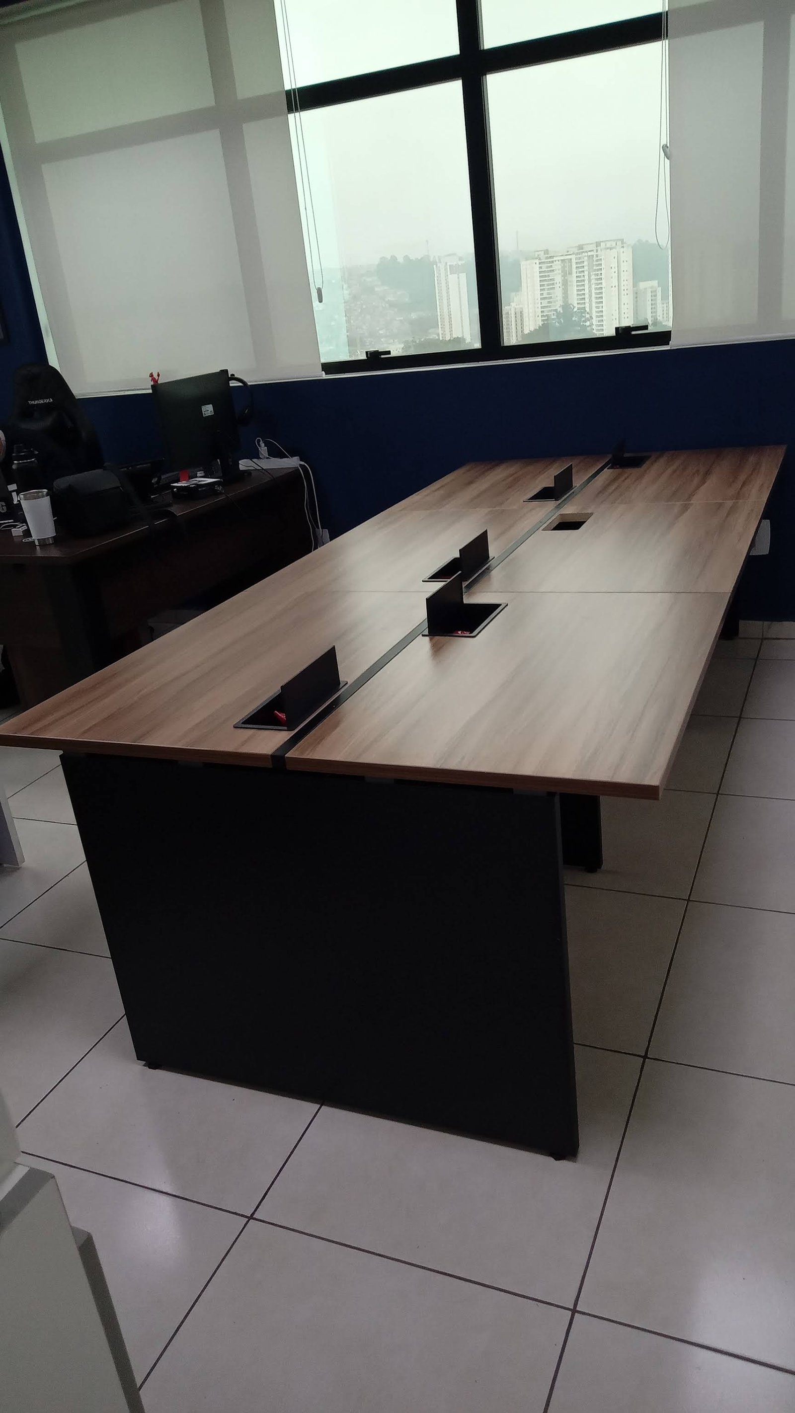 Mesa de trabalho de madeira montada junto à janela