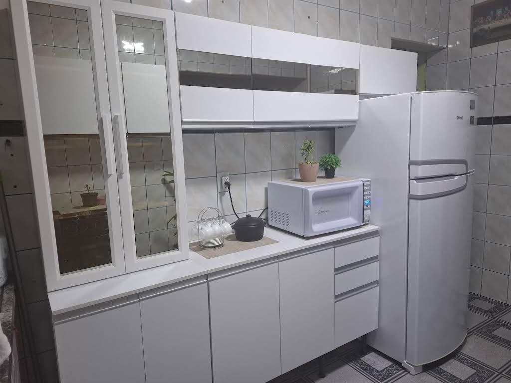 Armários brancos com portas de vidro em cozinha