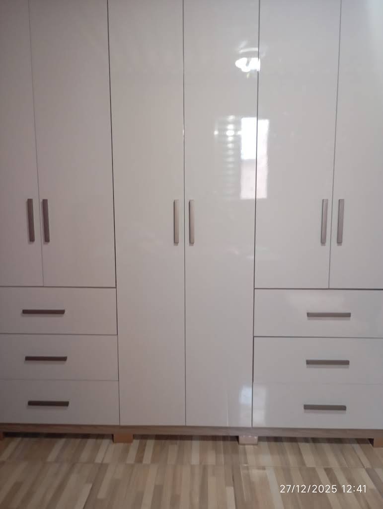 Guarda-roupa branco com gavetas e detalhes de madeira nas portas