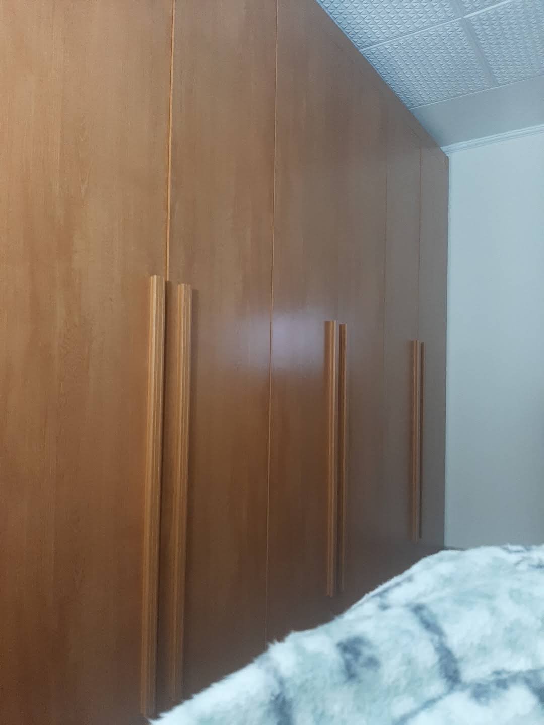 Guarda-roupa de madeira com puxadores verticais; foto publicada por Rosana Souza